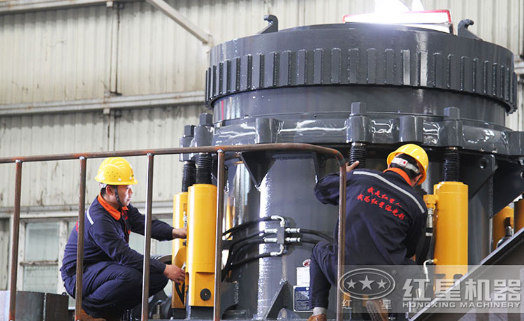 工作人員檢測圓錐破碎機(jī)，保障生產(chǎn)的設(shè)備都有高質(zhì)量